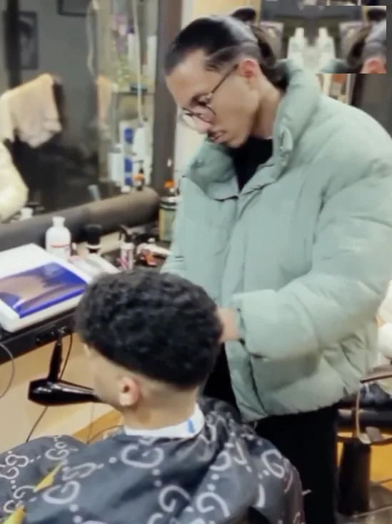 Le barbier en train de travailler une coupe bouclée au salon